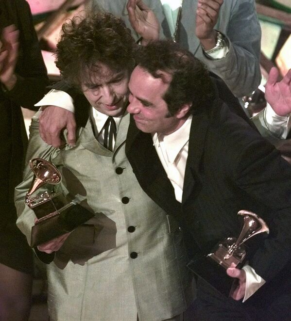 Боб Дилан (слева) и его продюсер Дэниел Лануа обнимаются после того, как певец выиграл альбом года на 40-й ежегодной премии «Грэмми» в Нью-Йорке - Sputnik Молдова