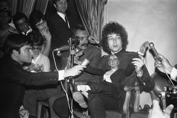 Американский фолк-певец Боб Дилан сидит с марионеткой перед журналистами во время пресс-конференции в отеле George V в Париже, Франция - Sputnik Молдова