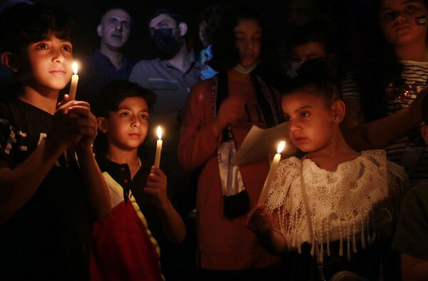 Дети держат свечи на территории разрушенного дома в результате бомбардировки в секторе Газа - Sputnik Moldova