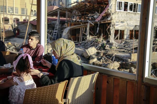 Oameni pe teritoriul unei case distruse din Fâșia Gaza - Sputnik Moldova-România