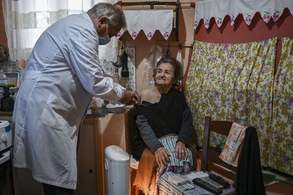 Доктор Анаргирос Мариолис вакцинирует пожилую женщину от Covid-19 на острове Элафониссос - Sputnik Молдова