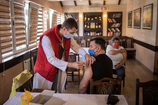 Мужчина получает дозу китайской вакцины Sinopharm против коронавирусной болезни (COVID-19) в ресторане в Крагуеваце, Сербия - Sputnik Молдова