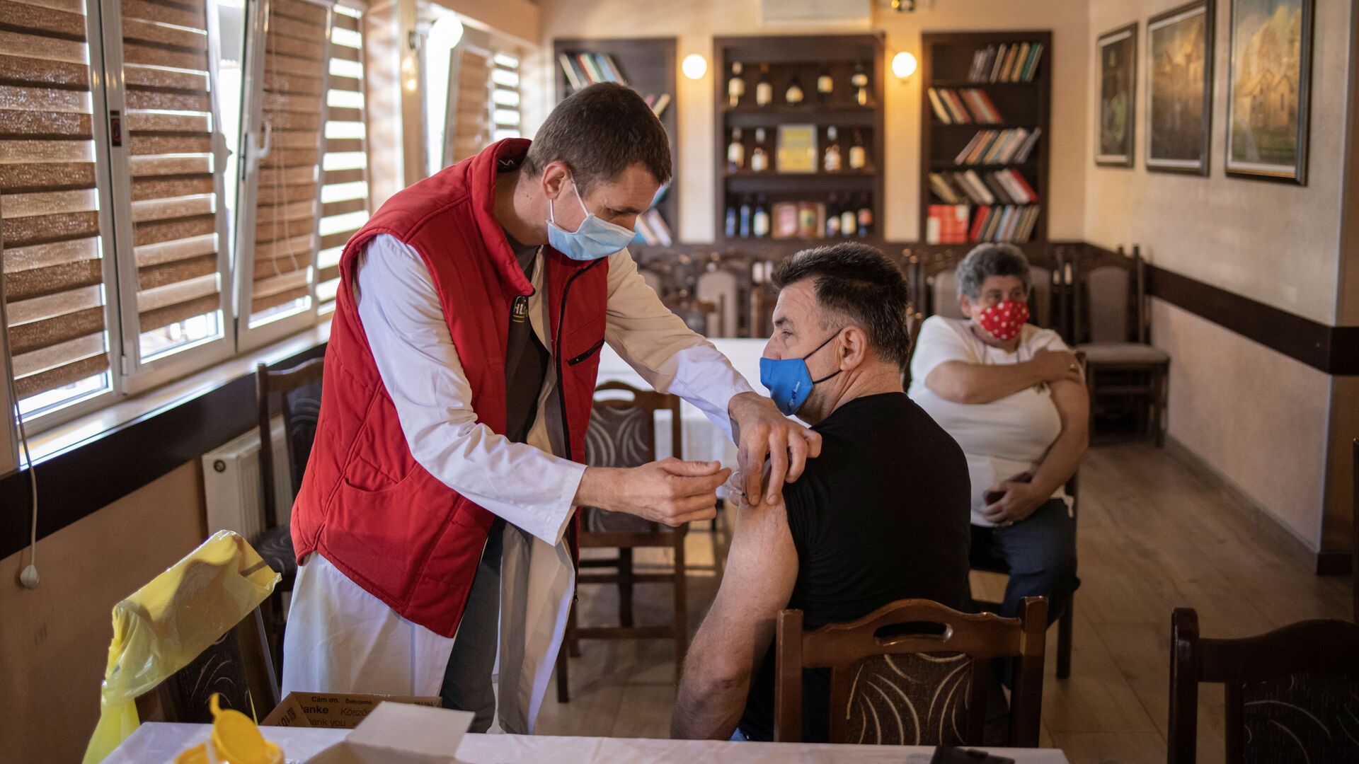 Мужчина получает дозу китайской вакцины Sinopharm против коронавирусной болезни (COVID-19) в ресторане в Крагуеваце, Сербия - Sputnik Moldova-România, 1920, 03.09.2021
