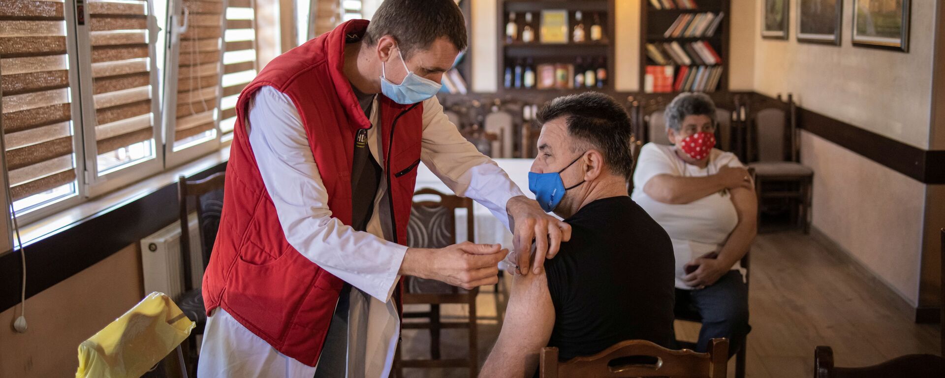 Мужчина получает дозу китайской вакцины Sinopharm против коронавирусной болезни (COVID-19) в ресторане в Крагуеваце, Сербия - Sputnik Moldova-România, 1920, 05.08.2021