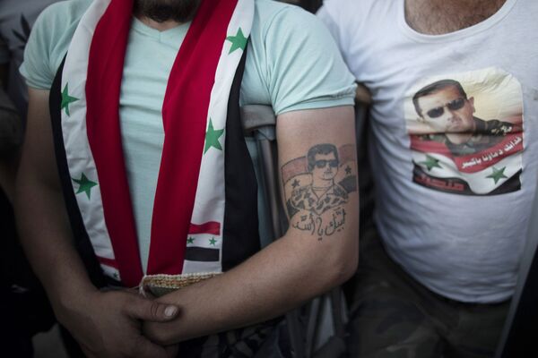 Раненый сирийский солдат с татуировкой президента Башара Асада во время празднования победы Асада на президентских выборах - Sputnik Moldova-România
