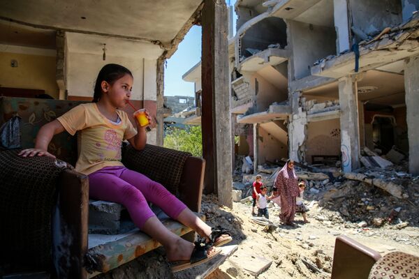 Девочка пьет сок в разрушенном доме на северо-востоке сектора Газа в городе Бейт-Ханун - Sputnik Молдова