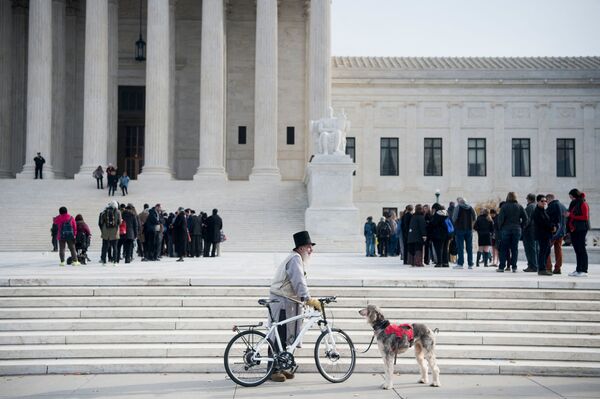 Мужчина с велосипедом и собакой у здания суда в Вашингтоне. - Sputnik Молдова
