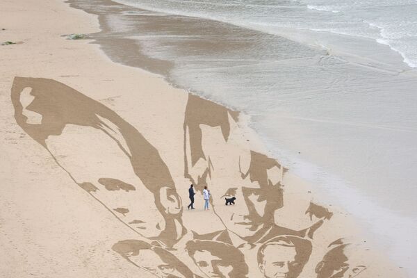 Гигантский рисунок с изображением лиц лидеров G7, созданного группой Avaaz, на пляже Уотергейт-Бэй, Ньюквей, Великобритания. - Sputnik Молдова