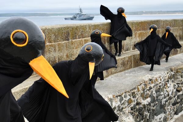 Активисты по борьбе с изменением климата, одетые как черные птицы, протестуют в Сент-Айвсе во время проведения саммита G7 в Корнуолле. - Sputnik Молдова