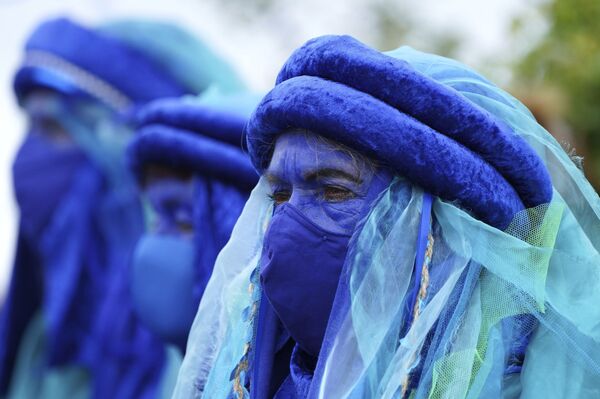 Климатические активисты одеты в синие костюмы на демонстрации возле встречи G7. - Sputnik Молдова