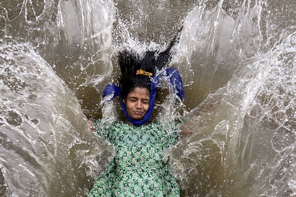 O fată care se joacă în apă afară după o ploaie puternică de musoni în Mumbai. - Sputnik Moldova-România