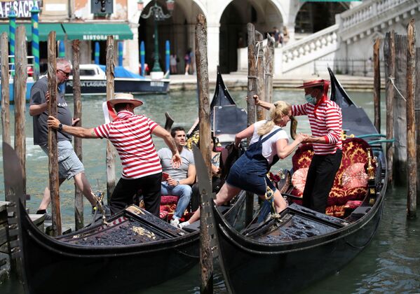 Gondolierii îi ajută pe turiști să intre în gondole, Veneția. - Sputnik Moldova-România