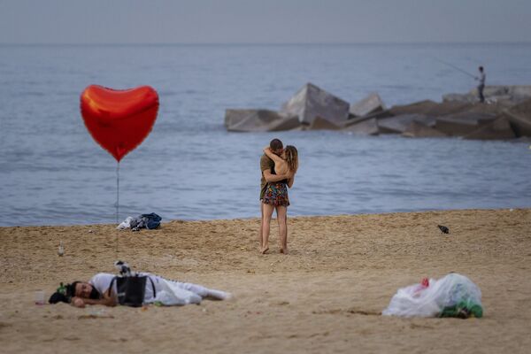 Пара целуется на пляже рано утром в Барселоне, Испания. - Sputnik Молдова