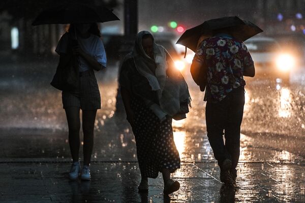 Pietoni pe o stradă din Moscova în timpul ploii puternice. - Sputnik Moldova