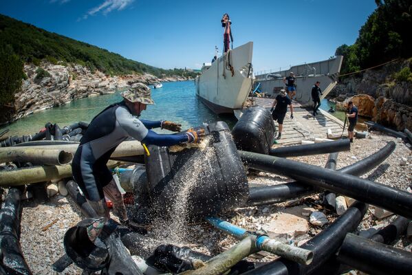 Волонтеры убирают остатки рыбной фермы на острове Итака, Греция. - Sputnik Молдова