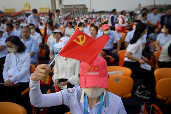 O femeie flutură un steag al Partidului Comunist din China înainte de evenimentul care marchează 100 de ani de la fondarea Partidului Comunist din China, la Beijing, China, 1 iulie 2021. - Sputnik Moldova-România