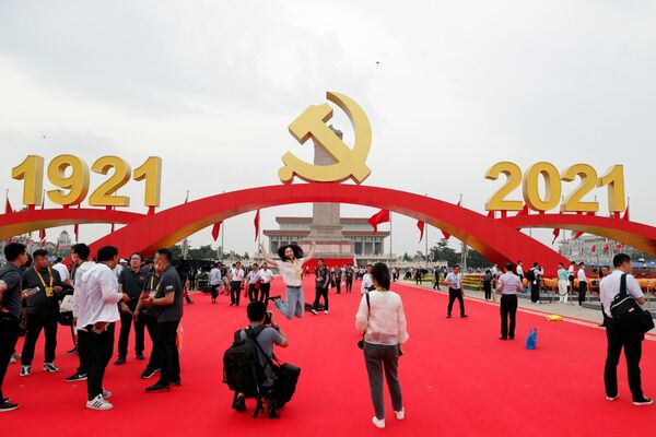 O femeie pozează cu emblema Partidului Comunist Chinez în Piața Tiananmen după evenimentul care a marcat 100 de ani de la fondarea Partidului Comunist din China, la Beijing, China, 1 iulie 2021. - Sputnik Moldova-România