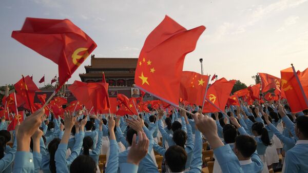 Участники праздновании 100-летия Коммунистической партии Китая с флагами в Пекине - Sputnik Молдова