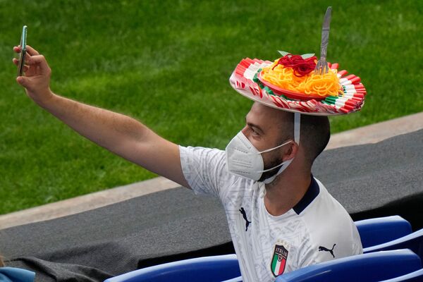 Un fan italian care poartă o pălărie spaghetti își face un selfie înainte de un meci de fotbal. - Sputnik Moldova-România