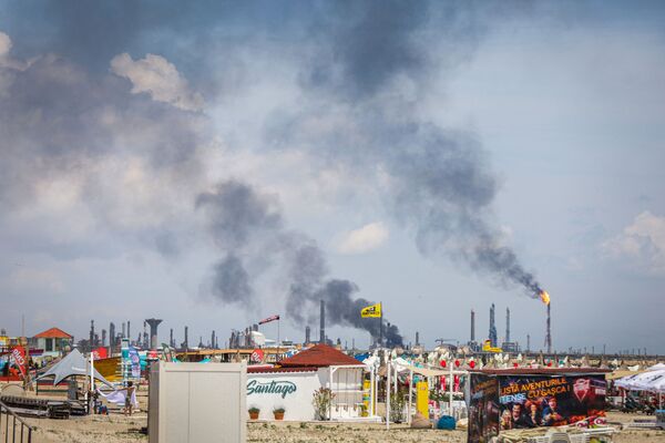 Imagine cu fumul care se înalță deasupra rafinăriei Petromidia. O perspectivă dinspre plaja Năvodari. 2 iulie 2021 - Sputnik Moldova-România