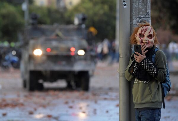 Демонстрант в маске во время акции протеста против правительства Колумбии - Sputnik Молдова