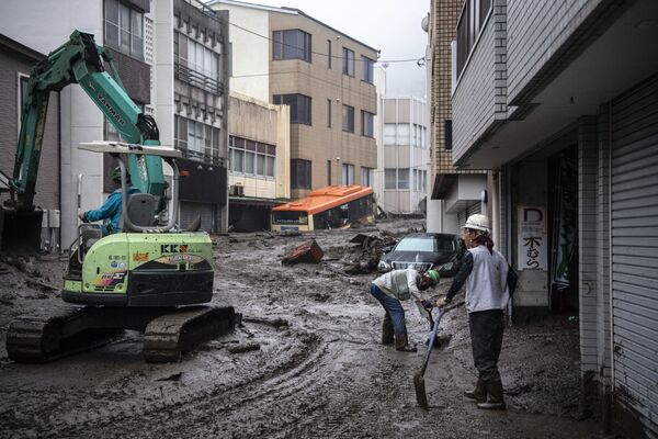 Workers remove mud and debris at the scene of a landslide following days of heavy rain in Atami in Shizuoka Prefecture on July 3, 2021. - Sputnik Молдова
