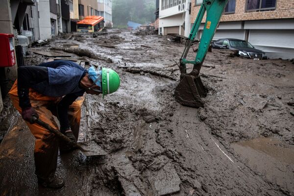 A rescue worker removes mud and debris at the scene of a landslide following days of heavy rain in Atami in Shizuoka Prefecture on July 3, 2021. - Sputnik Молдова