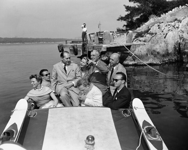 Итальянский кинорежиссер Роберто Росселлини и его жена, актриса Ингрид Бергман отплывают на гоночной лодке после обеда на Каннском кинофестивале, 1956 год. - Sputnik Молдова
