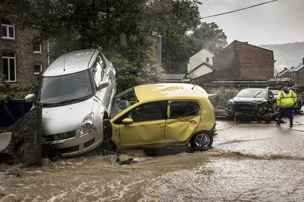 Поврежденные машины на затопленной улице в Мери, Бельгия. - Sputnik Молдова