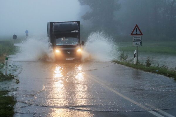 Автомобиль едет по дороге, пострадавшей от наводнения, Германия. - Sputnik Молдова