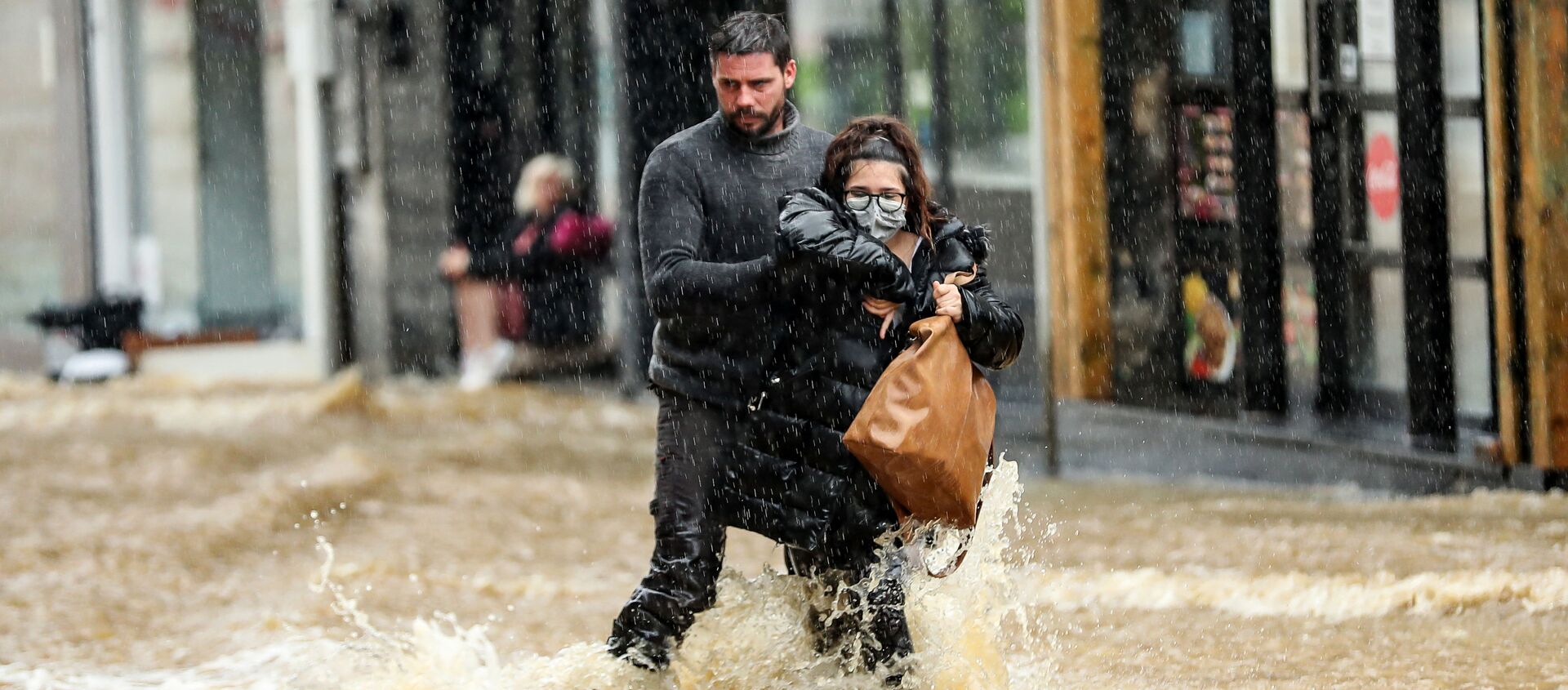 Мужчина помогает женщине пройтись по затопленной улице в городе Спа, Бельгия - Sputnik Moldova-România, 1920, 16.07.2021