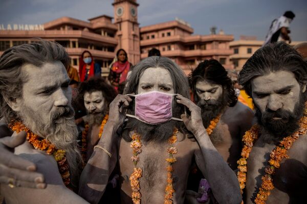 Нага Садху надевает маску перед процессией для купания в реке Ганг на Фестивале кувшинов в Харидваре, Индия. - Sputnik Молдова