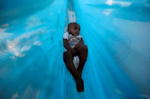 Sakina, în vârstă de 11 luni, doarme într-un hamac pe malul unui lac din Mumbai, India. - Sputnik Moldova
