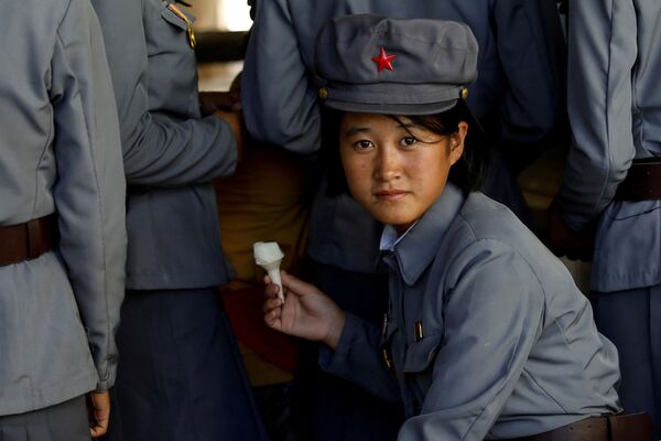 Военнослужащая ест мороженное во время похода в Пхеньянский зоопарк. - Sputnik Молдова