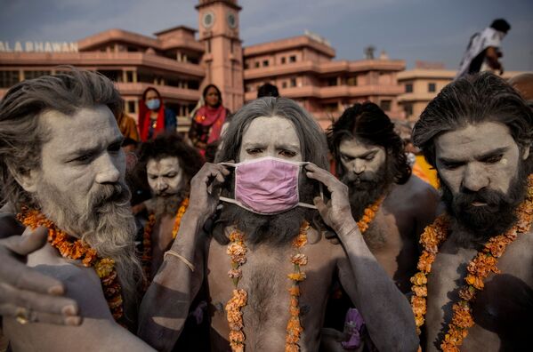 Naga Sadhu poartă o mască înainte de o procesiune de scăldat în râul Gange la festivalul Jug din Haridwar, India - Sputnik Moldova-România