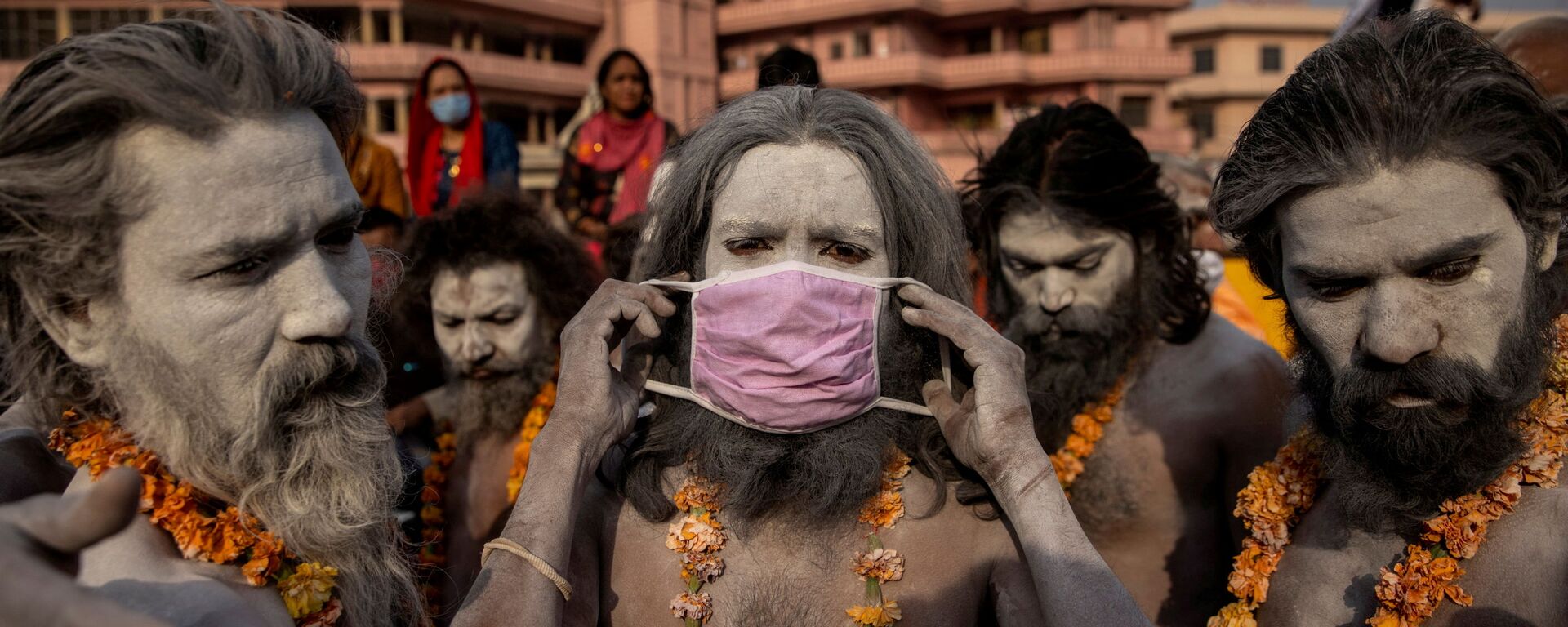 Нага Садху надевает маску перед процессией для купания в реке Ганг на Фестивале кувшинов в Харидваре, Индия - Sputnik Молдова, 1920, 10.08.2021