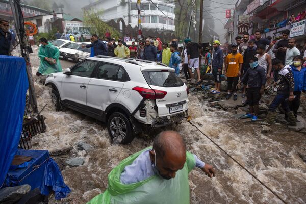 Люди пытаются вытянуть автомобиль, поврежденный во время наводнений после сильных муссонных дождей в Индии. - Sputnik Молдова