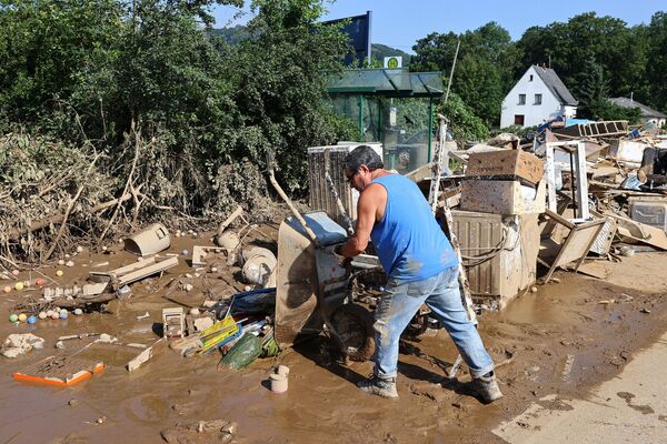 Un bărbat descarcă noroi după o inundație din Germania - Sputnik Moldova-România