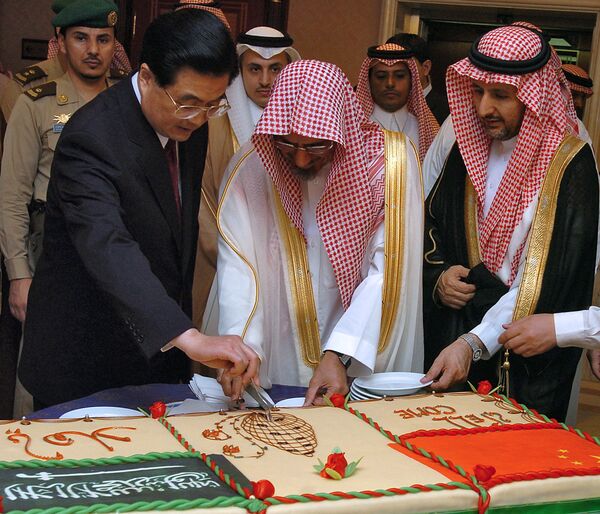 Председатель консультативного совета саудовской шуры шейх Салех бин Хумайд (второй слева) и президент Китая Ху Цзиньтао (слева) разрезают торт после выступления Цзиньтао на совете шуры в Эр-Рияде 23 апреля 2006 года. - Sputnik Молдова