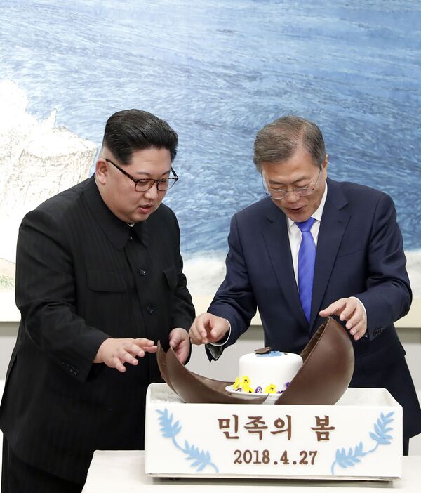 Лидер Северной Кореи Ким Чен Ын (слева) и президент Южной Кореи Мун Чжэ Ин (справа) смотрят на торт с шоколадным куполом во время банкета в приграничной деревне Пханмунджом.. - Sputnik Молдова