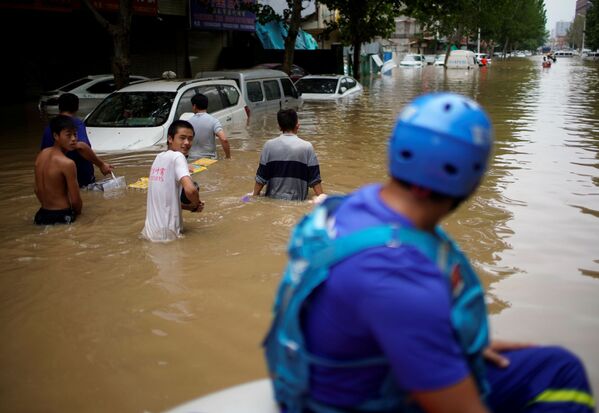 Люди на затопленной улице в китайской провинции Хэнань  - Sputnik Moldova