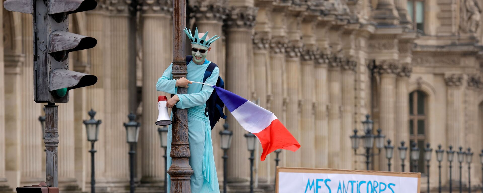 Демонстрант в костюме статуи Свободы принимает участие в акции протеста против объявленных президентом Франции Эммануэлем Макроном новых мер по борьбе со вспышкой коронавируса в Париже, Франция - Sputnik Молдова, 1920, 24.07.2021
