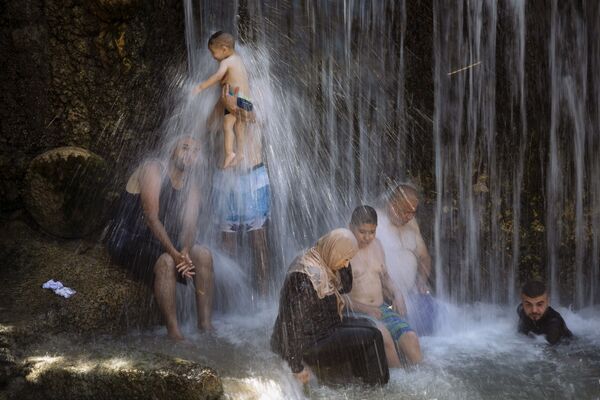 Израильские арабы стоят под водопадом во время мусульманского праздника Курбан-байрам в национальном парке Ган-ха-Шлоша. - Sputnik Молдова