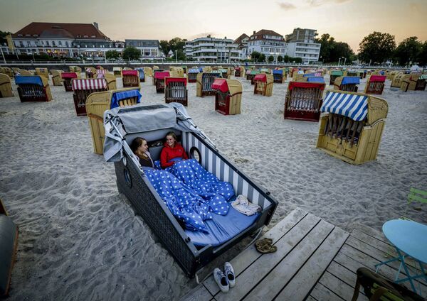 Две девушки готовятся провести ночь в специально разработанном шезлонге на пляже Балтийского моря в Травемюнде, Германия. - Sputnik Молдова
