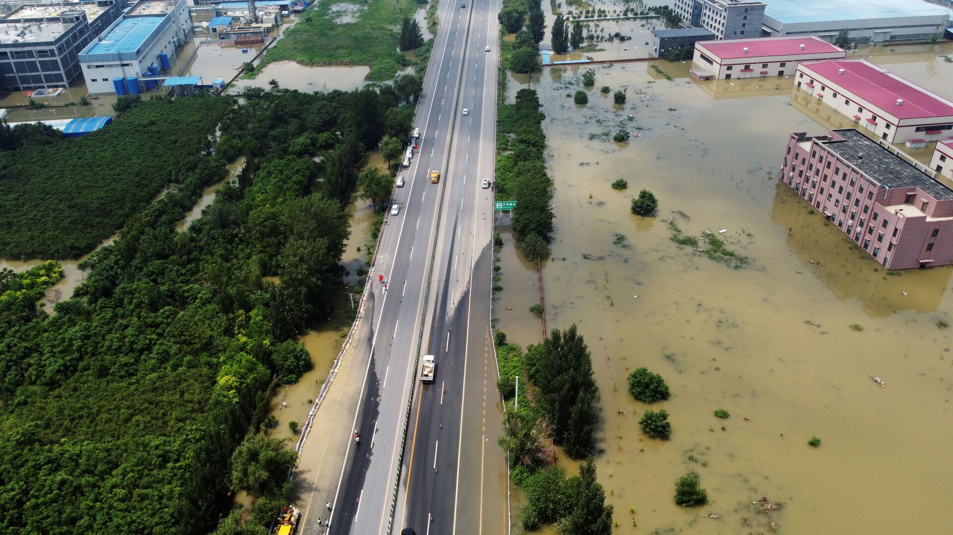 Затопленные промышленные здания у шоссе после проливного дождя в Синьсяне, провинция Хэнань, Китай - Sputnik Moldova-România, 1920, 30.07.2021