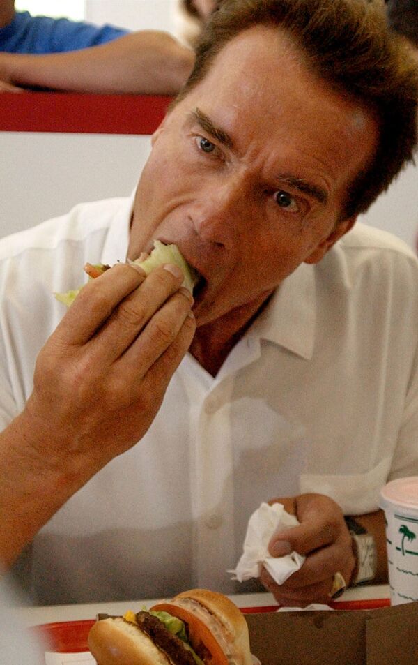 Арнольд Шварценеггер, в должности губернатора Калифорнии пробует гамбургер, завернутый в листья салата, в одном из ресторанов. - Sputnik Молдова