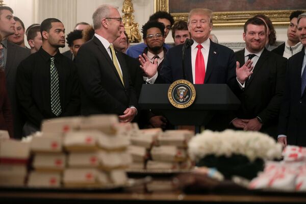 Президент США Дональд Трамп угощает гамбургерами членов футбольной команды Национального чемпиона в Белом доме в Вашингтоне. - Sputnik Молдова