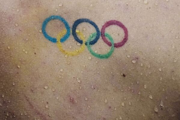 Капли воды падают на спину с татуировкой олимпийских колец пловца Таунли Хааса из США. - Sputnik Молдова