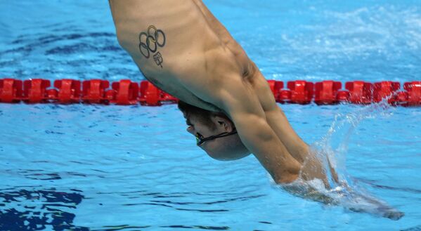 Пловец с олимпийской татуировкой во время тренировки на летних Олимпийских играх Токио-2020. - Sputnik Молдова