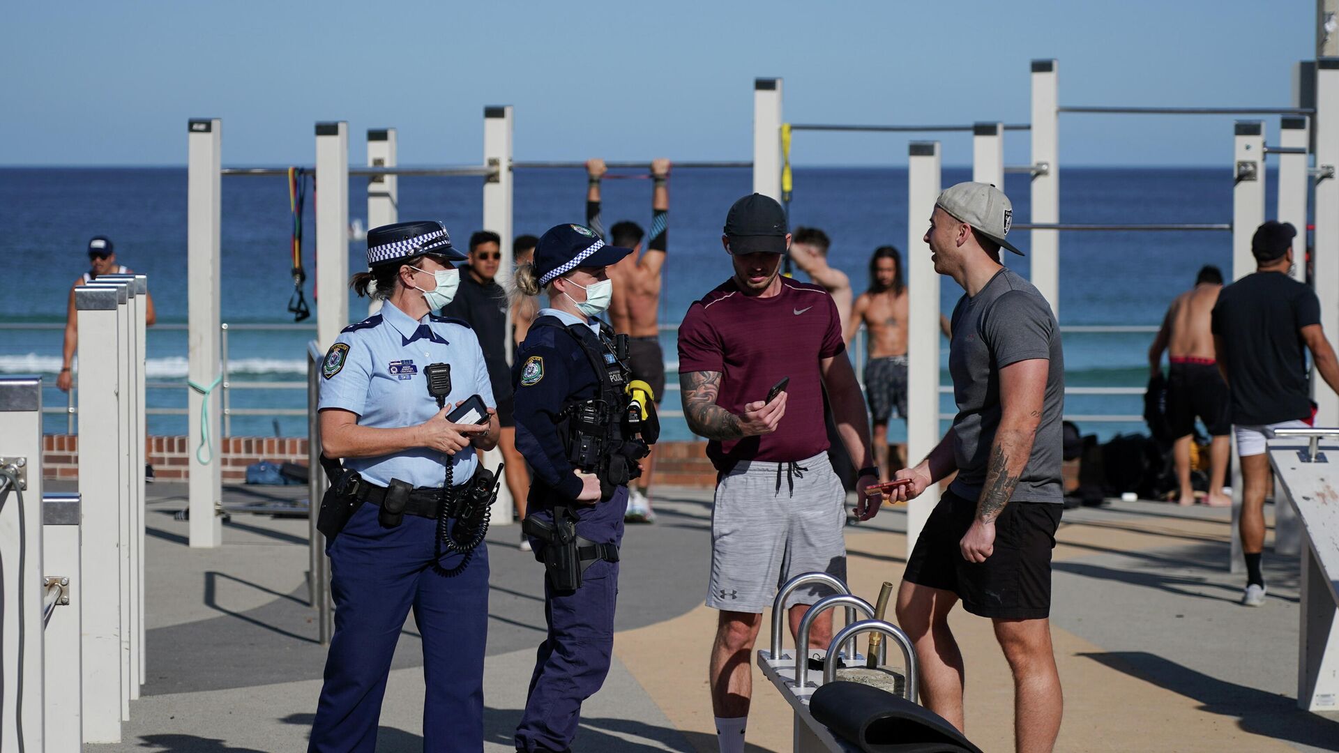 Ofițerii de poliție verifică actele de identitate în timp ce pun în aplicare un blocaj al coronavirusului într-o zonă de gimnastică în aer liber de pe plaja Bondi, în Sydney, Australia, 27 iulie 2021 - Sputnik Moldova-România, 1920, 28.07.2021